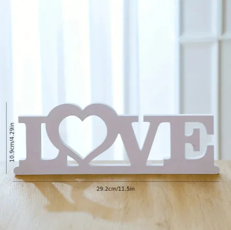 Decorative sign with 'I love' on a wooden surface