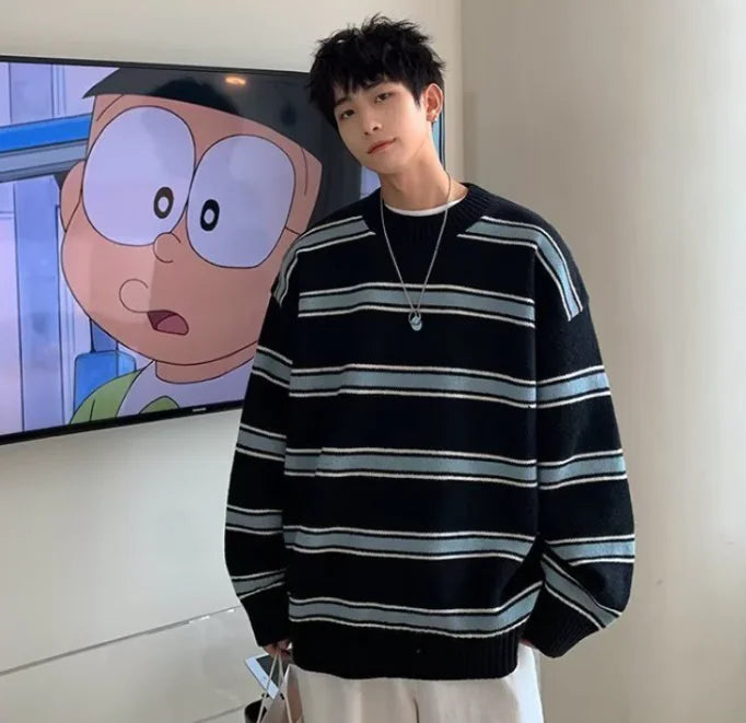 Person wearing a black and white striped sweater standing in front of a screen displaying an animated character.