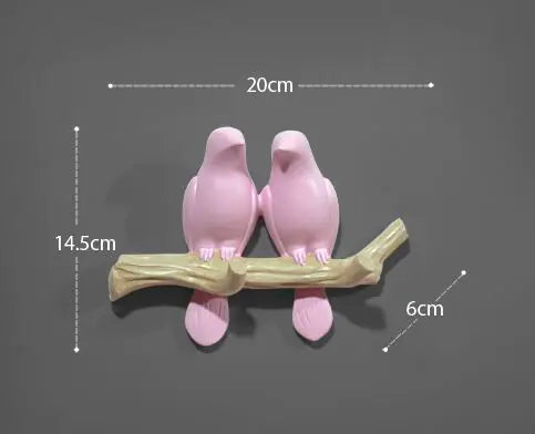 Two pink bird-shaped objects on a branch with measurements indicated.