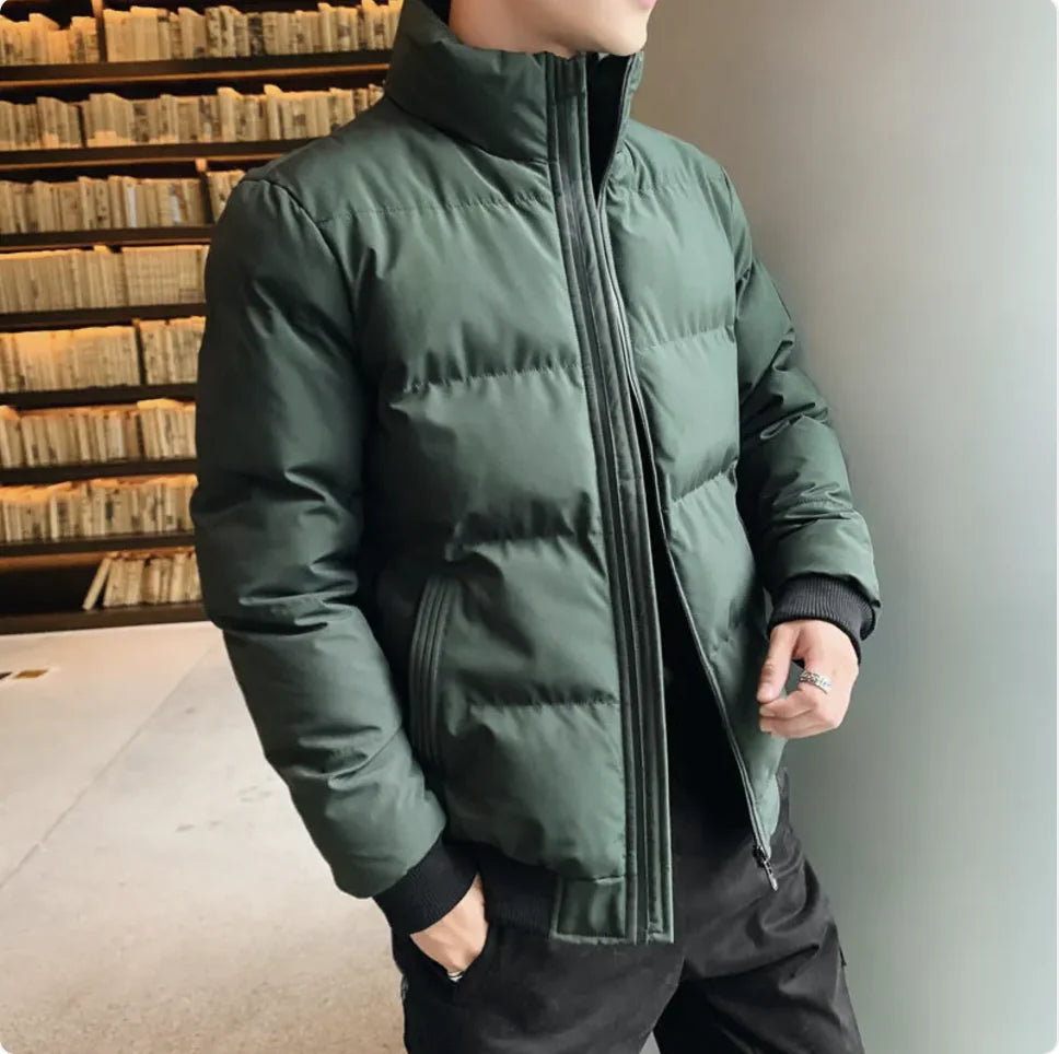 Person wearing a green puffer jacket indoors with a neutral background
