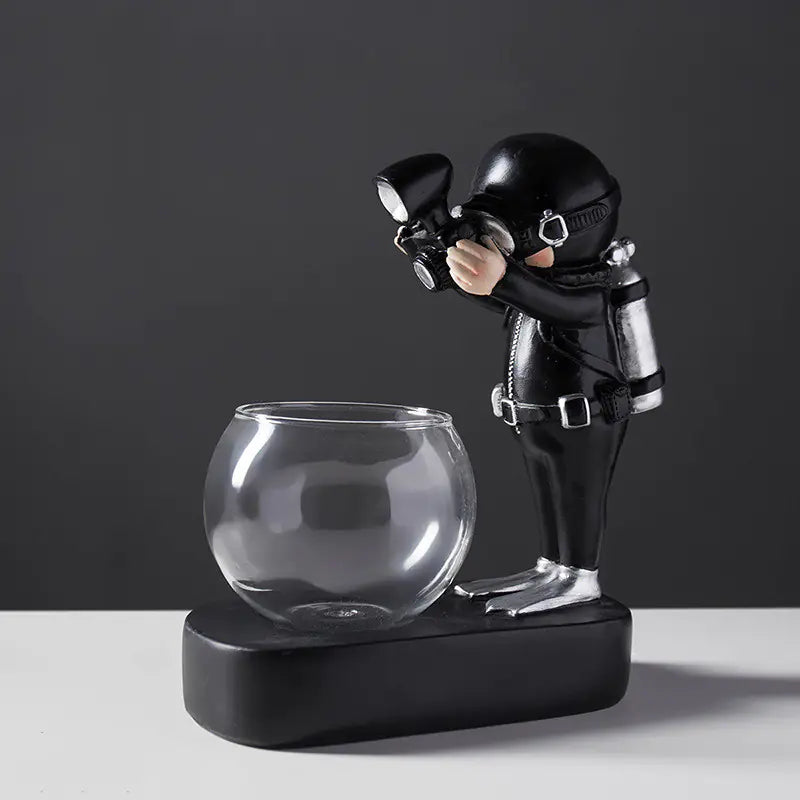 Decorative figure of a astronaut with a glass bowl on a black background