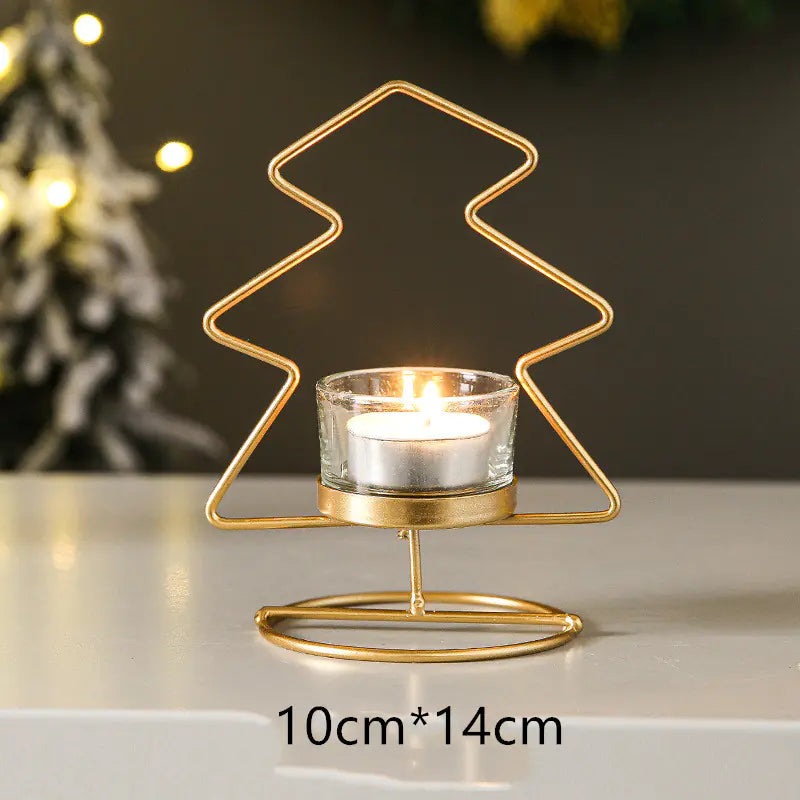 Gold Christmas tree-shaped candle holder with a lit candle on a neutral background