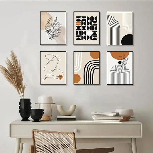 Set of abstract wall art prints on a wall above a desk with decorative items.